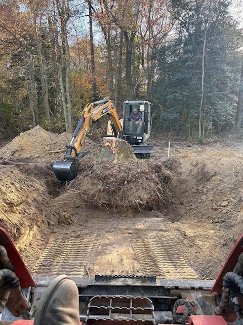 A man is driving a bulldozer in a dirt field.