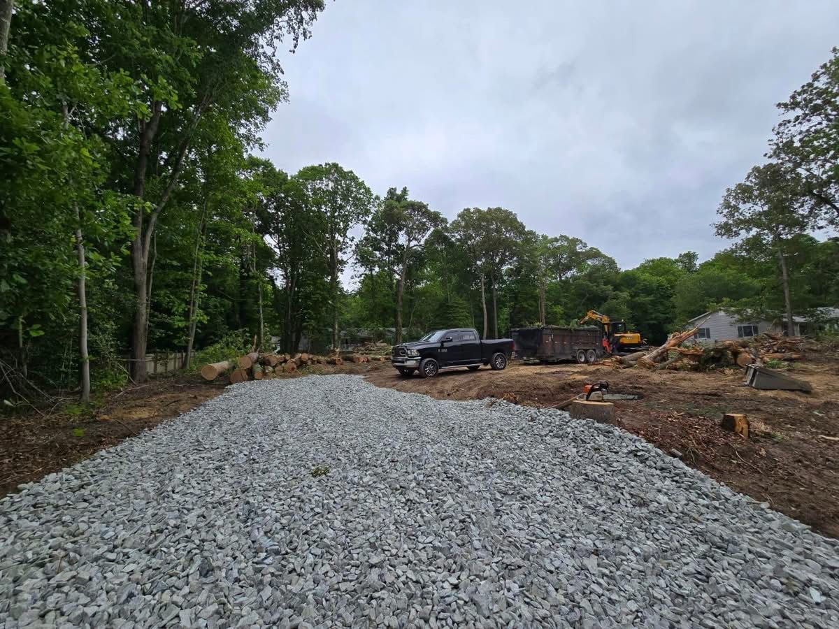 A gravel road with a truck parked on the side of it.