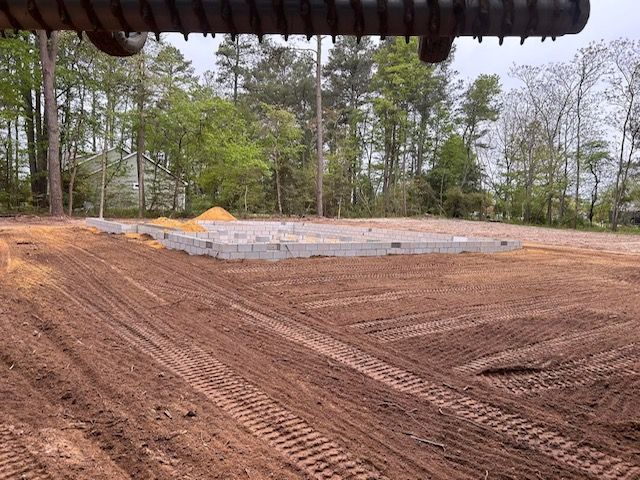 A large dirt field with a few trees in the background.