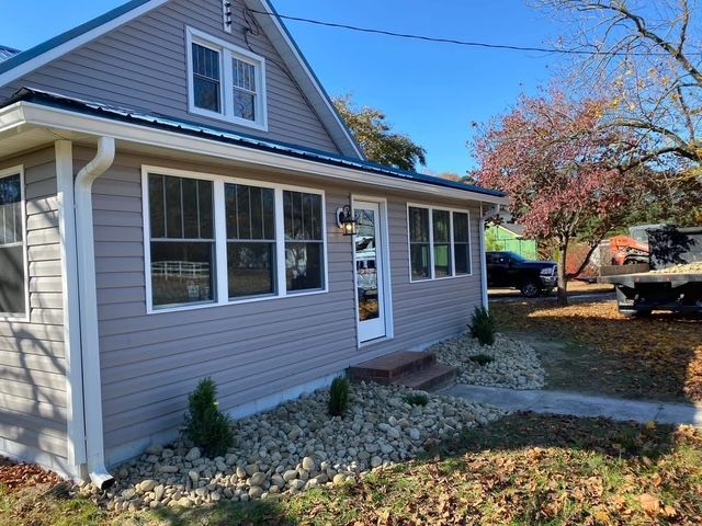 A house with a lot of windows and a truck parked in front of it.
