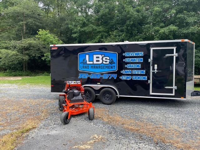 A lawn mower is parked next to a trailer that says lbs