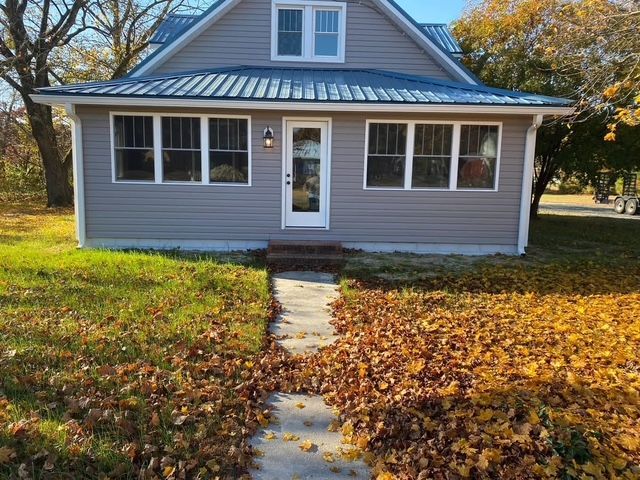 A small house with a blue roof and a walkway leading to it