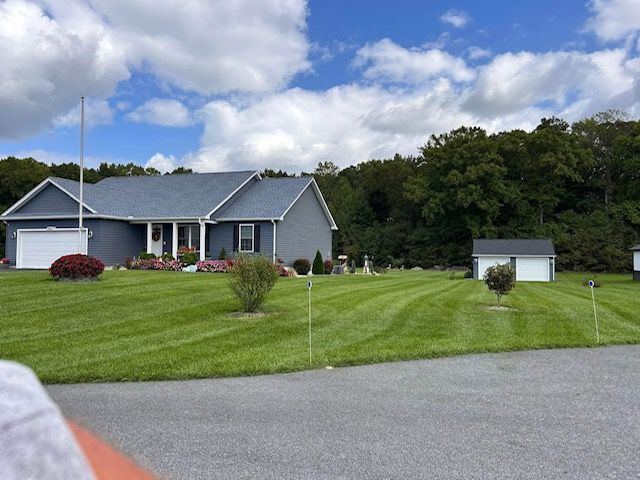 A house with a lush green lawn in front of it