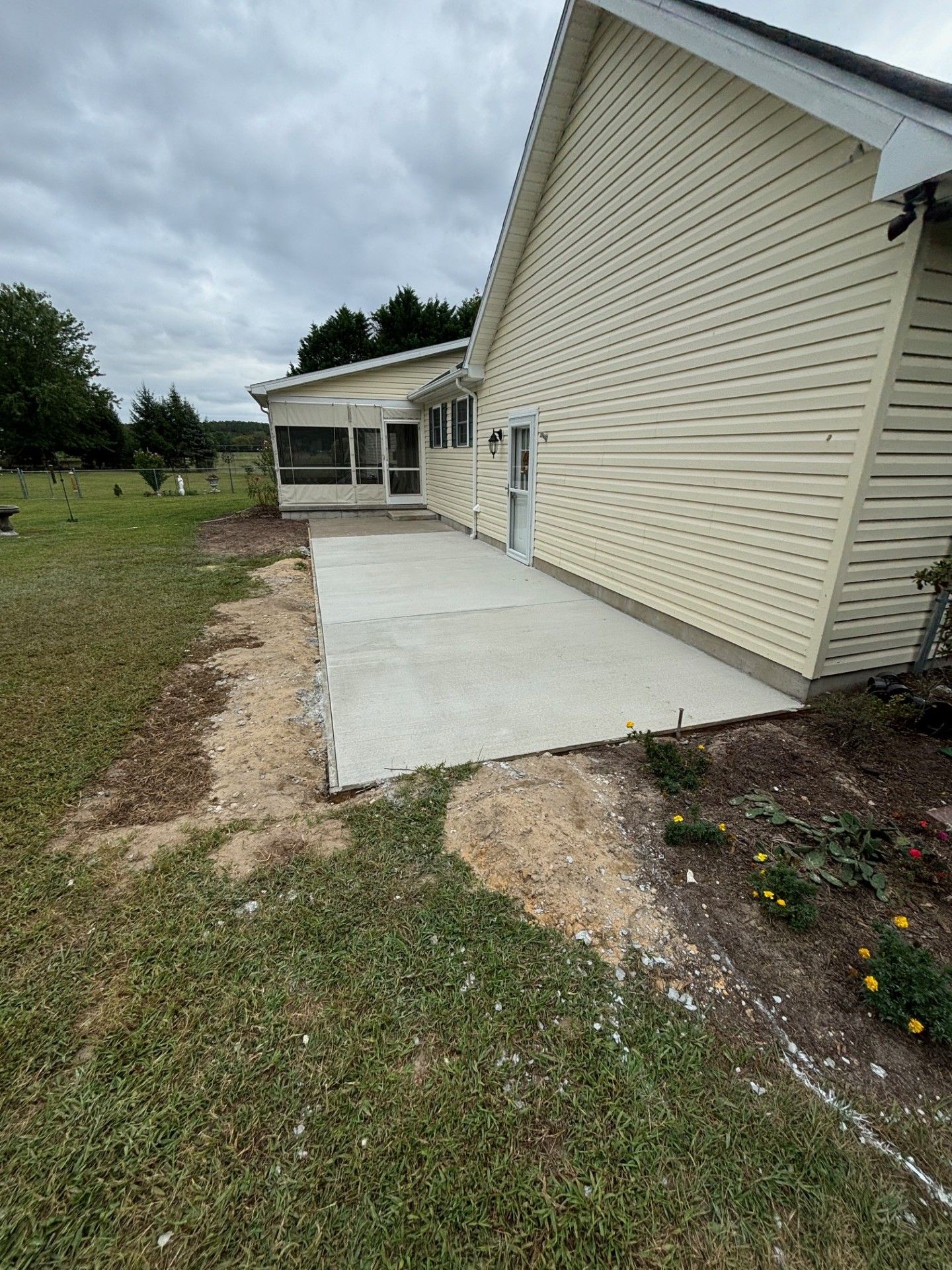 A concrete walkway is being built in front of a house.