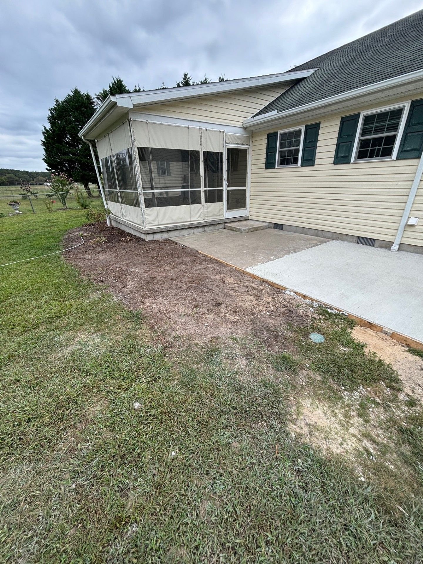 A house with a screened in porch and a concrete walkway.