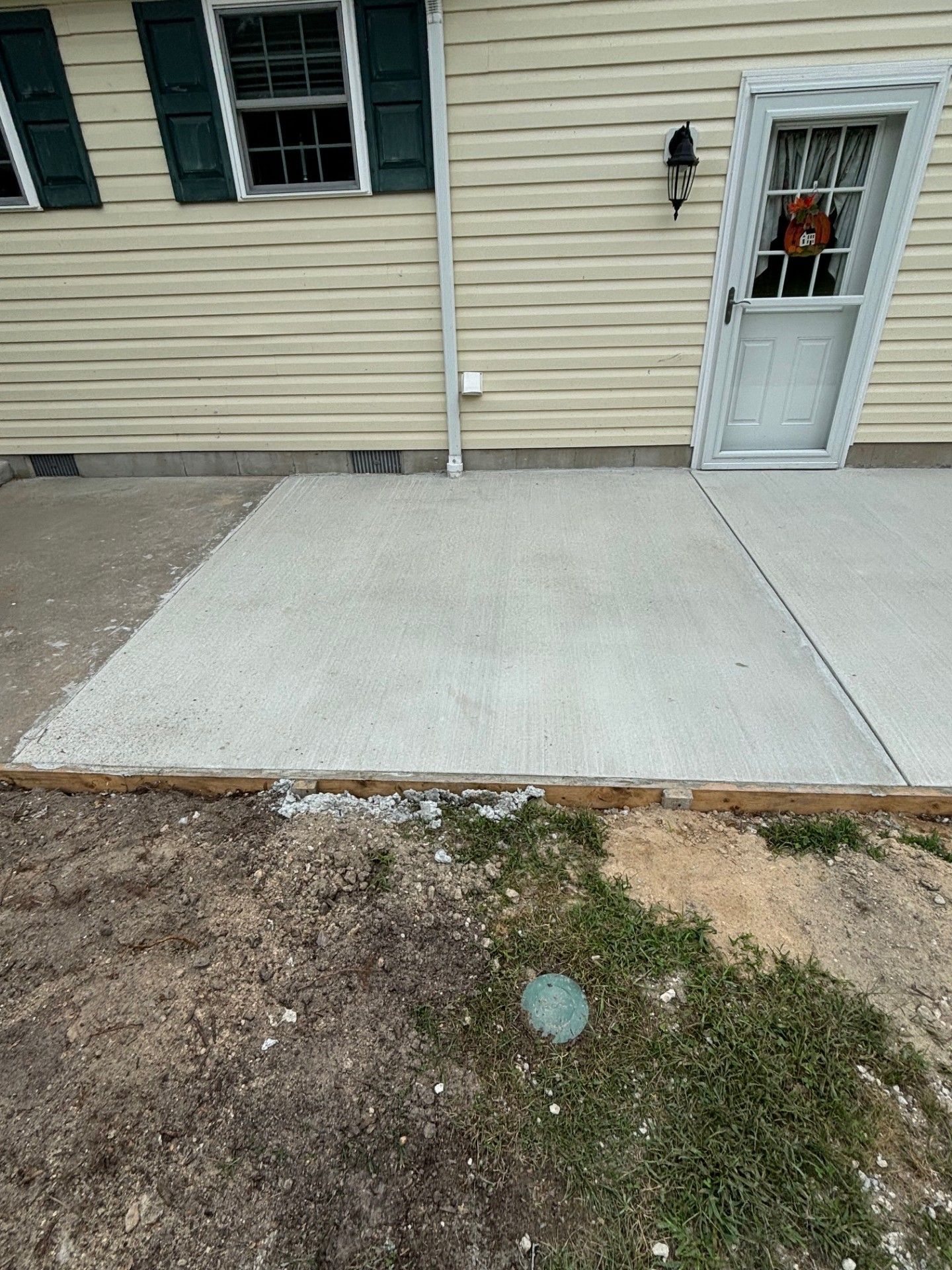 A concrete patio in front of a house with a door.