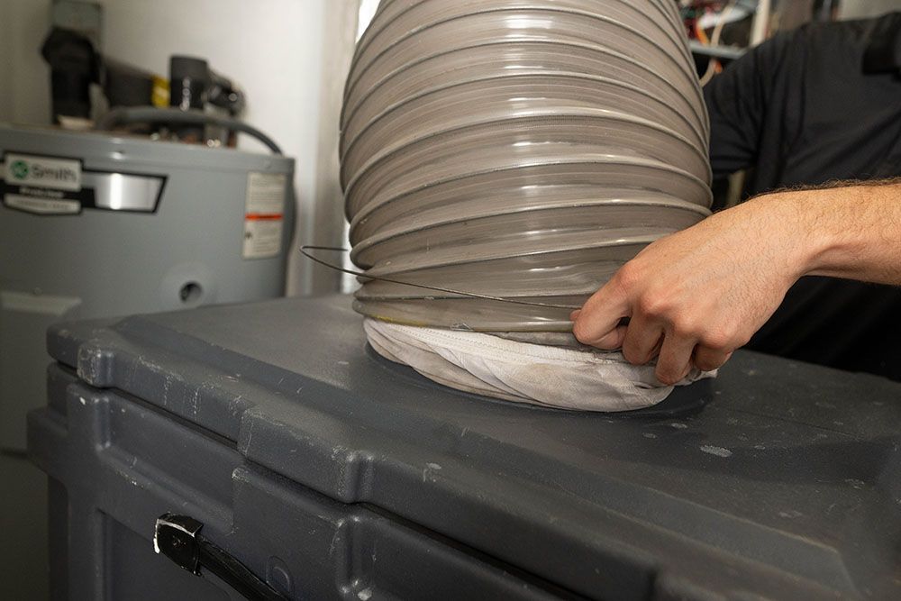 a man is holding a hose on top of a box.