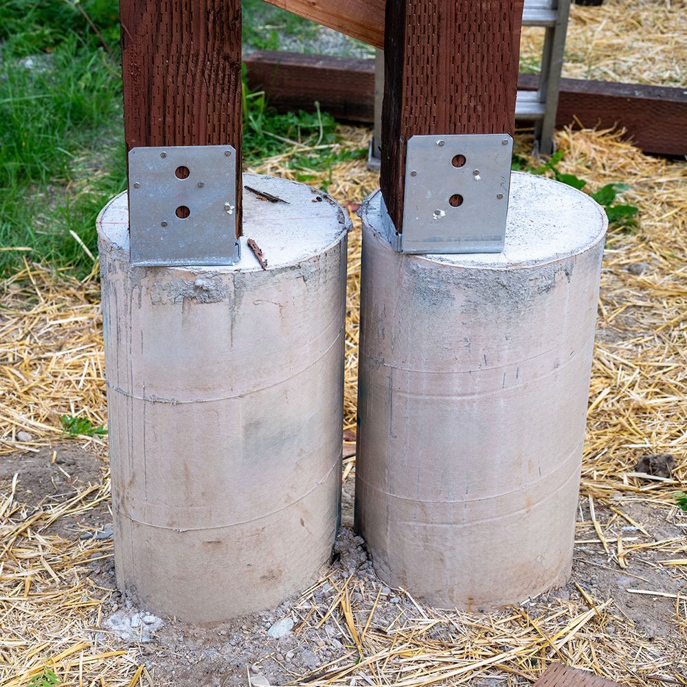 Two concrete pillars with metal brackets attached to them