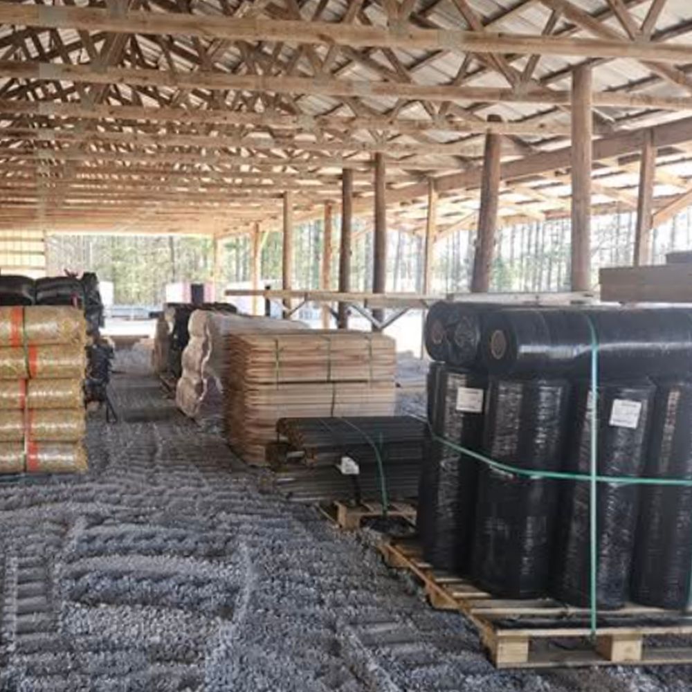 A warehouse filled with lots of rolls of erosion control material.