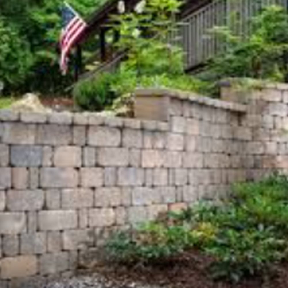 A brick wall with an american flag flying in the background.