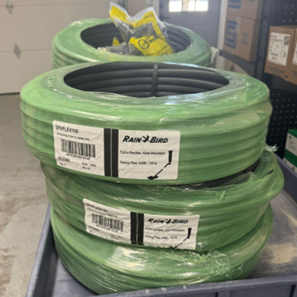 Three rolls of rain bird hose are stacked on top of each other