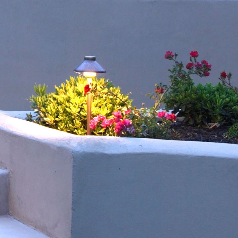 A planter with flowers and a light on top of it