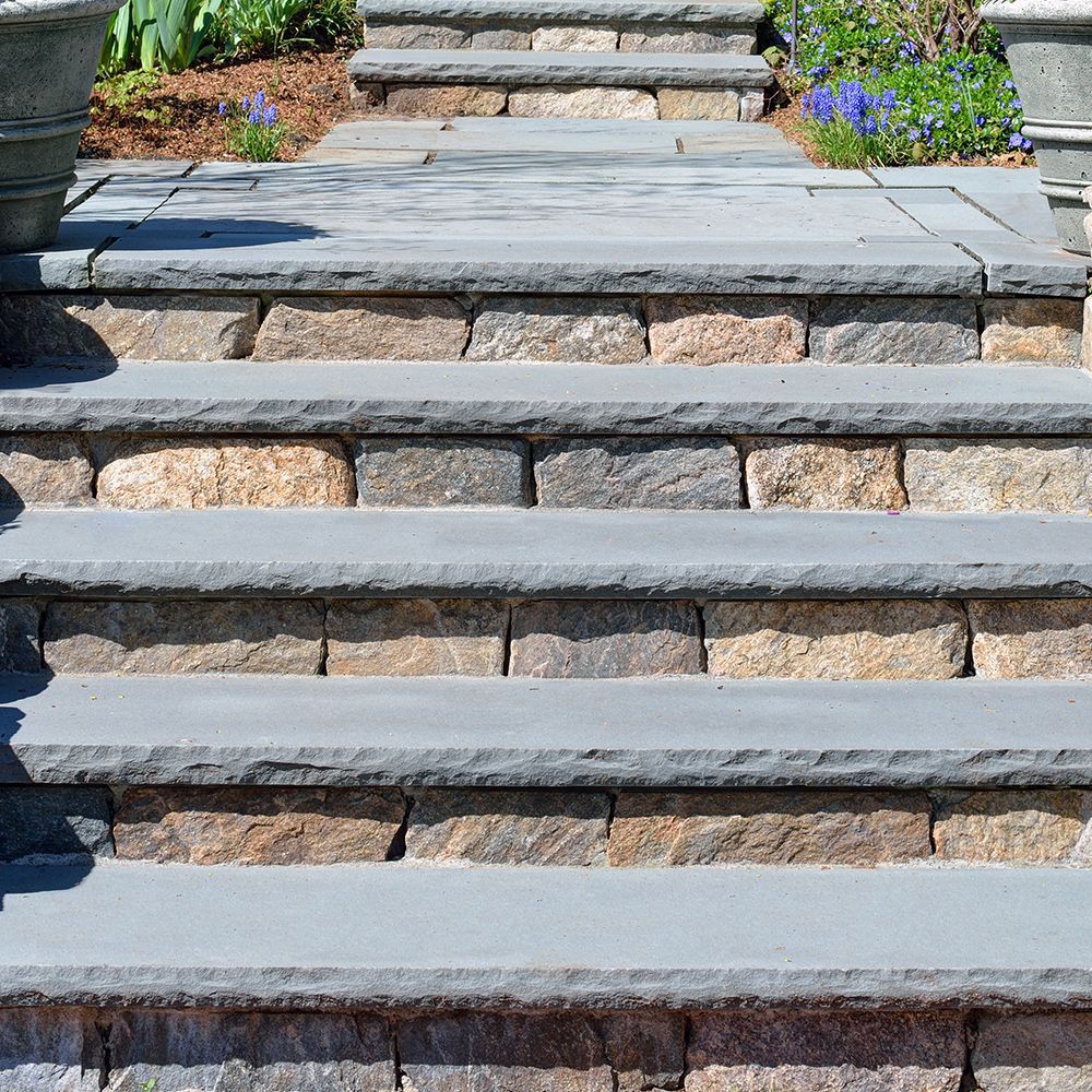A set of stone stairs leading up to a garden.