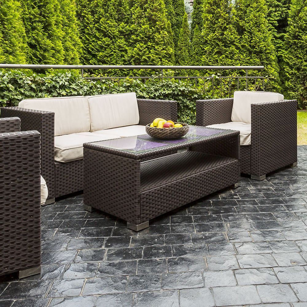 A patio with wicker furniture and a bowl of fruit on the table.