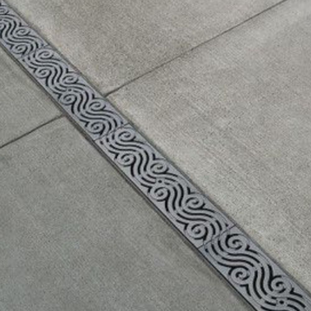 A drain on a sidewalk with a pattern on it