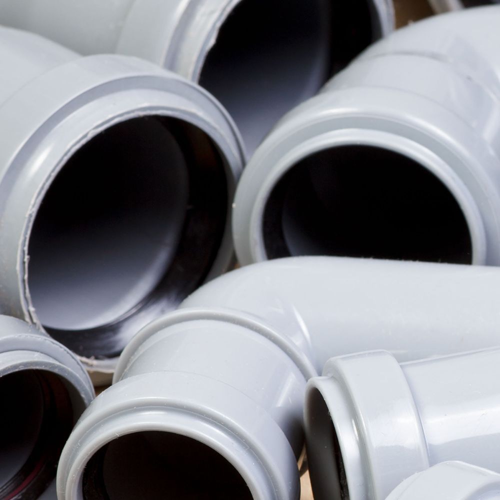 A bunch of gray pipes are stacked on top of each other