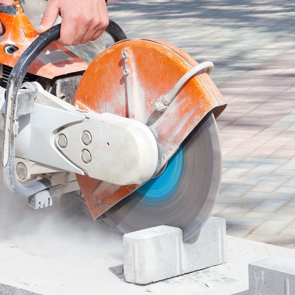 A person is using a circular saw to cut bricks