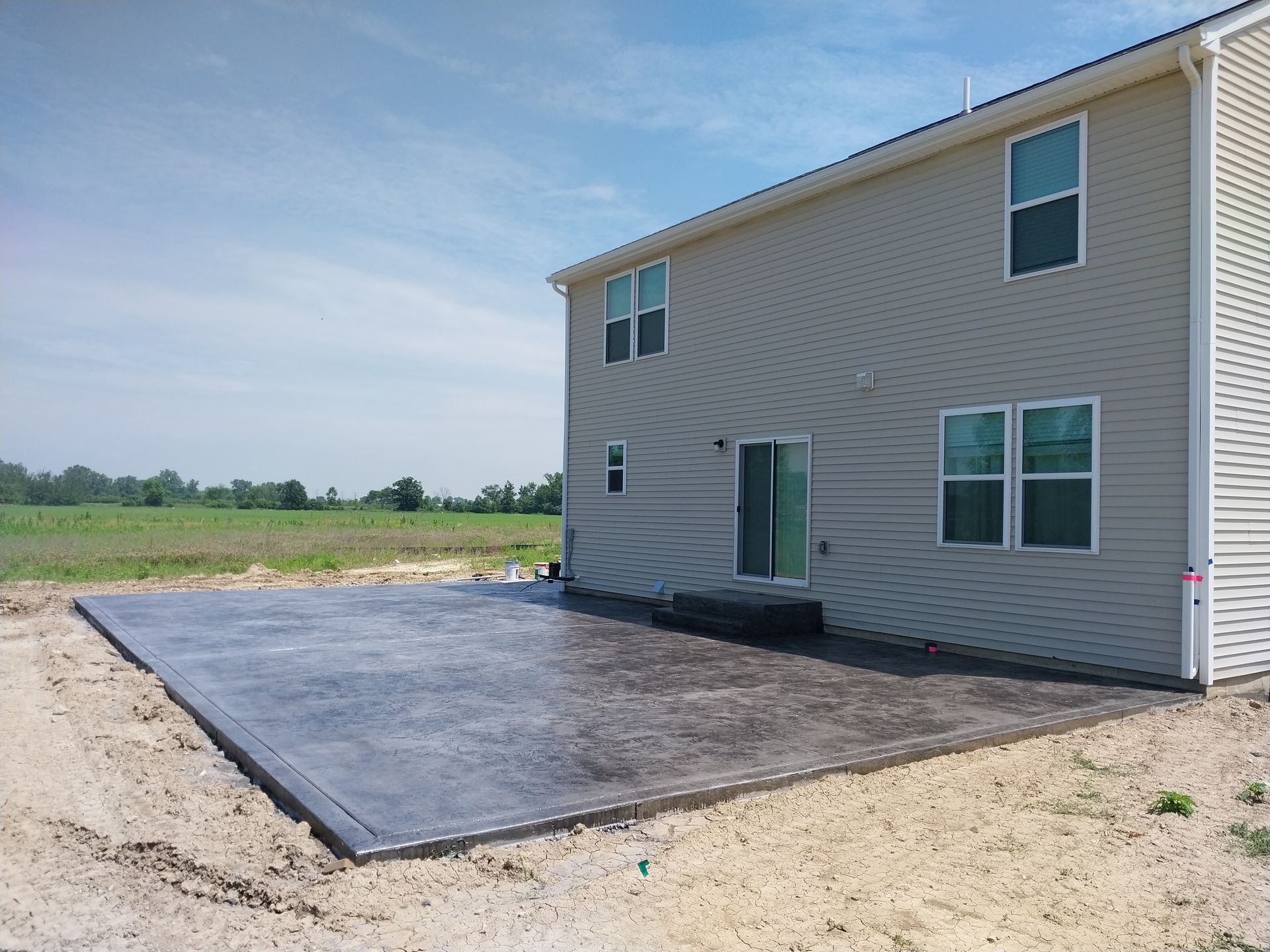 A large house with a large concrete patio in front of it.