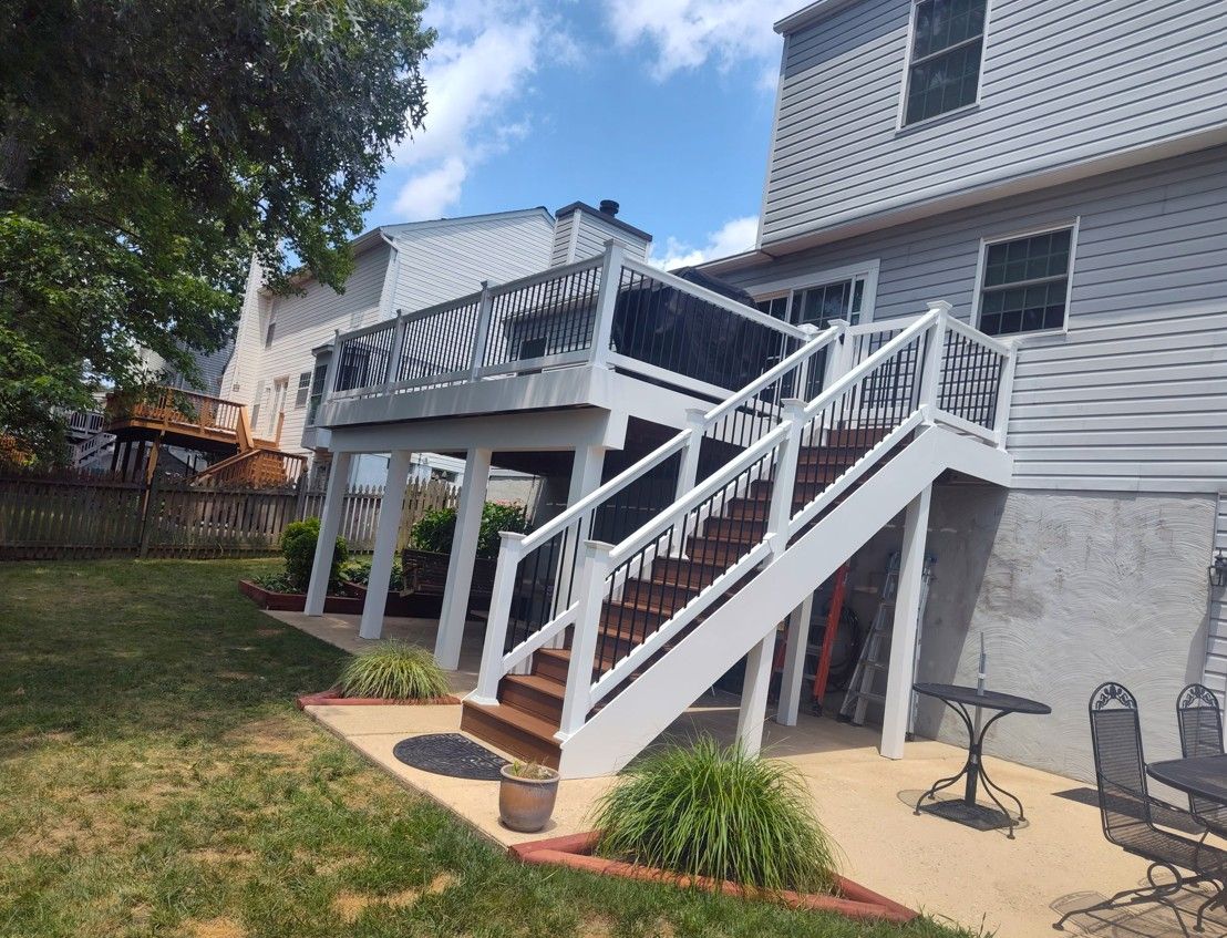 A house with a deck and stairs in the backyard.