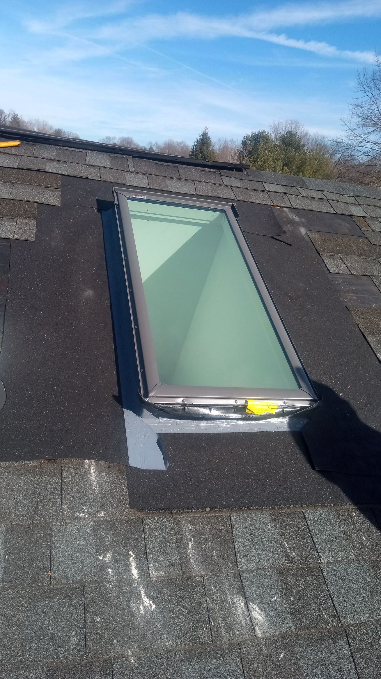 A skylight is sitting on top of a roof.