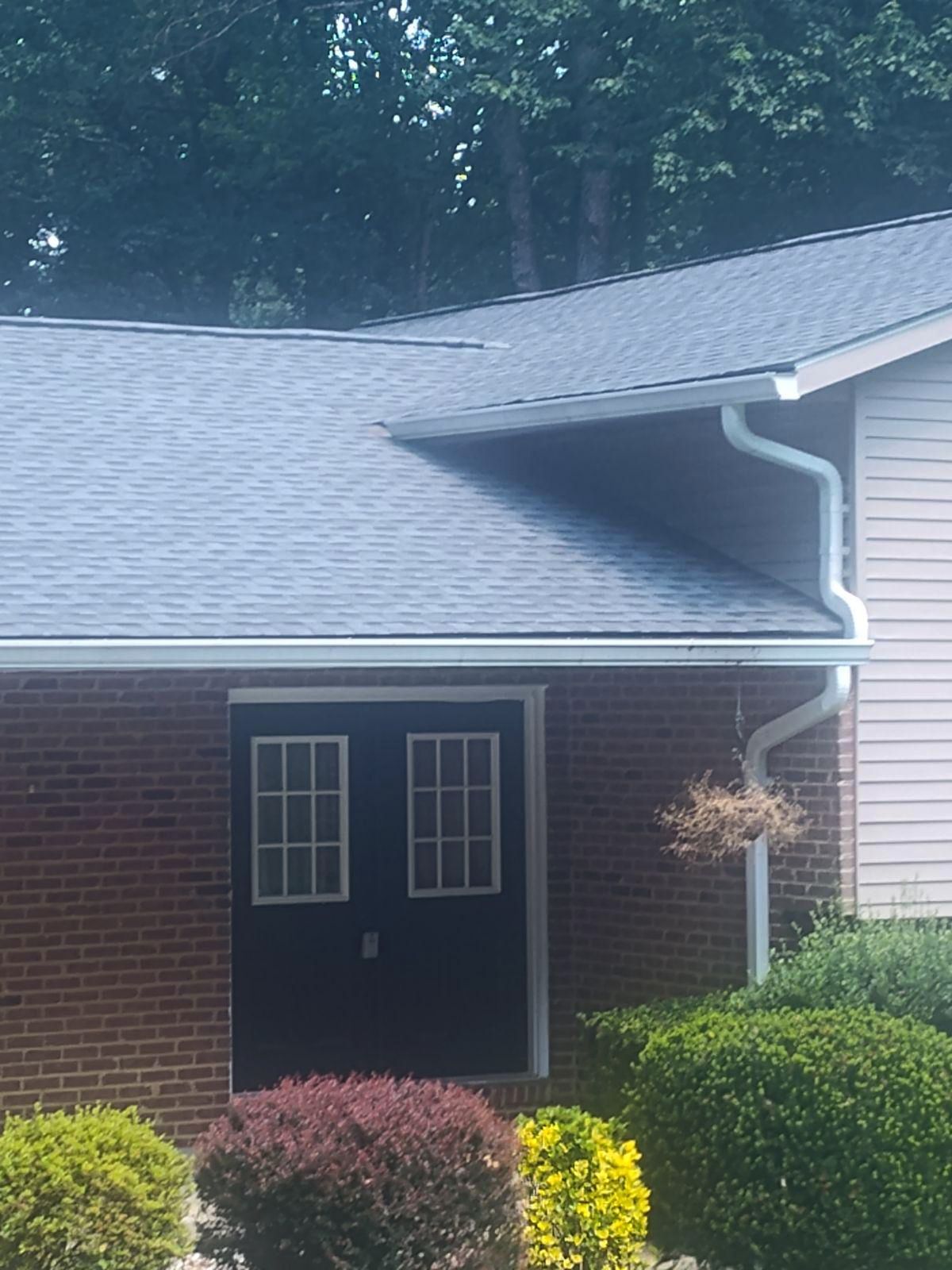 A brick house with a blue roof and white siding