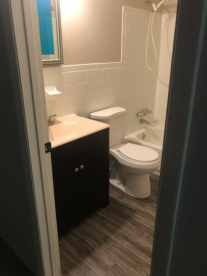 A bathroom with a toilet , sink , and bathtub.