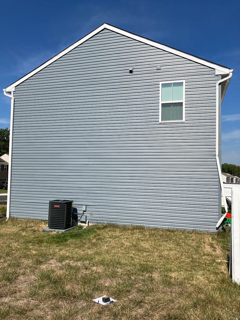 The back of a house with a fence and a window.