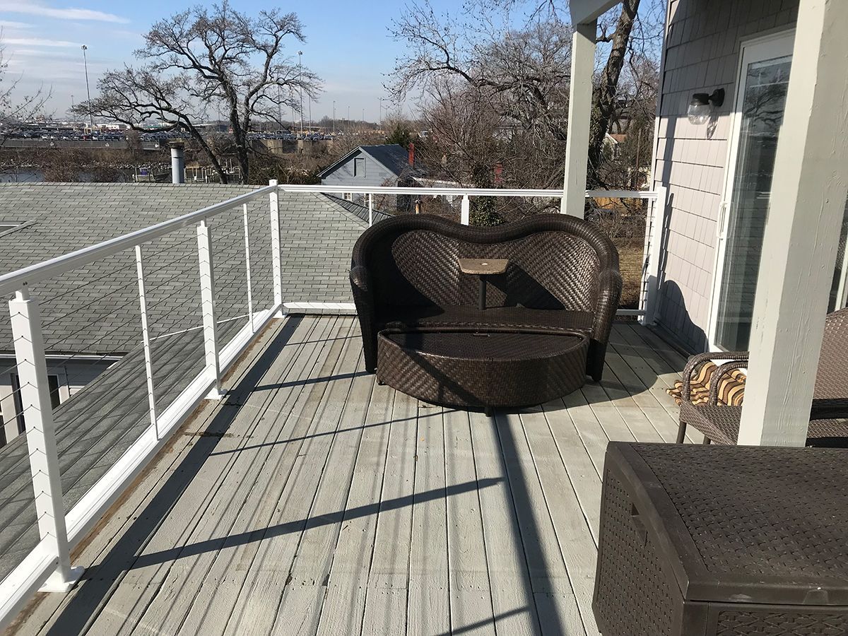 There is a heart shaped chair on the balcony.