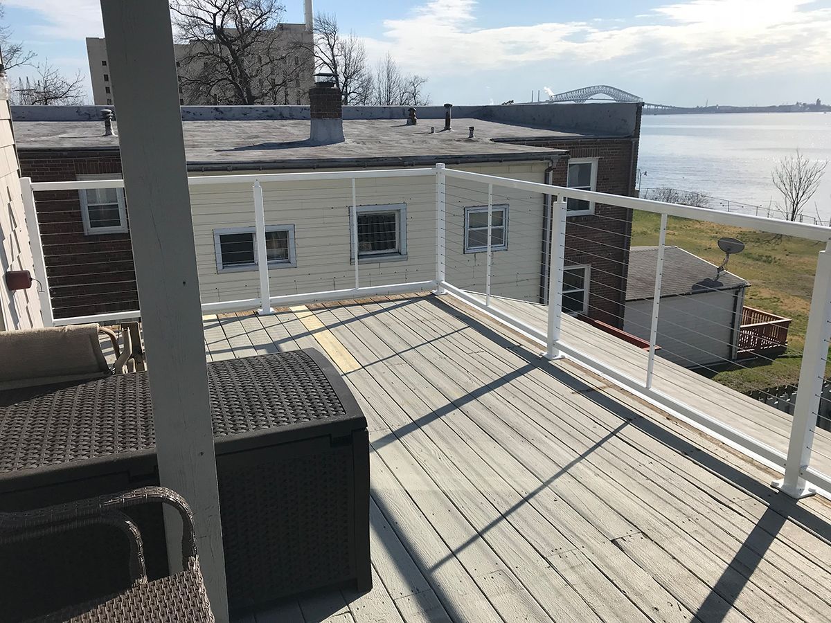 A balcony with a view of a body of water and a building in the background.