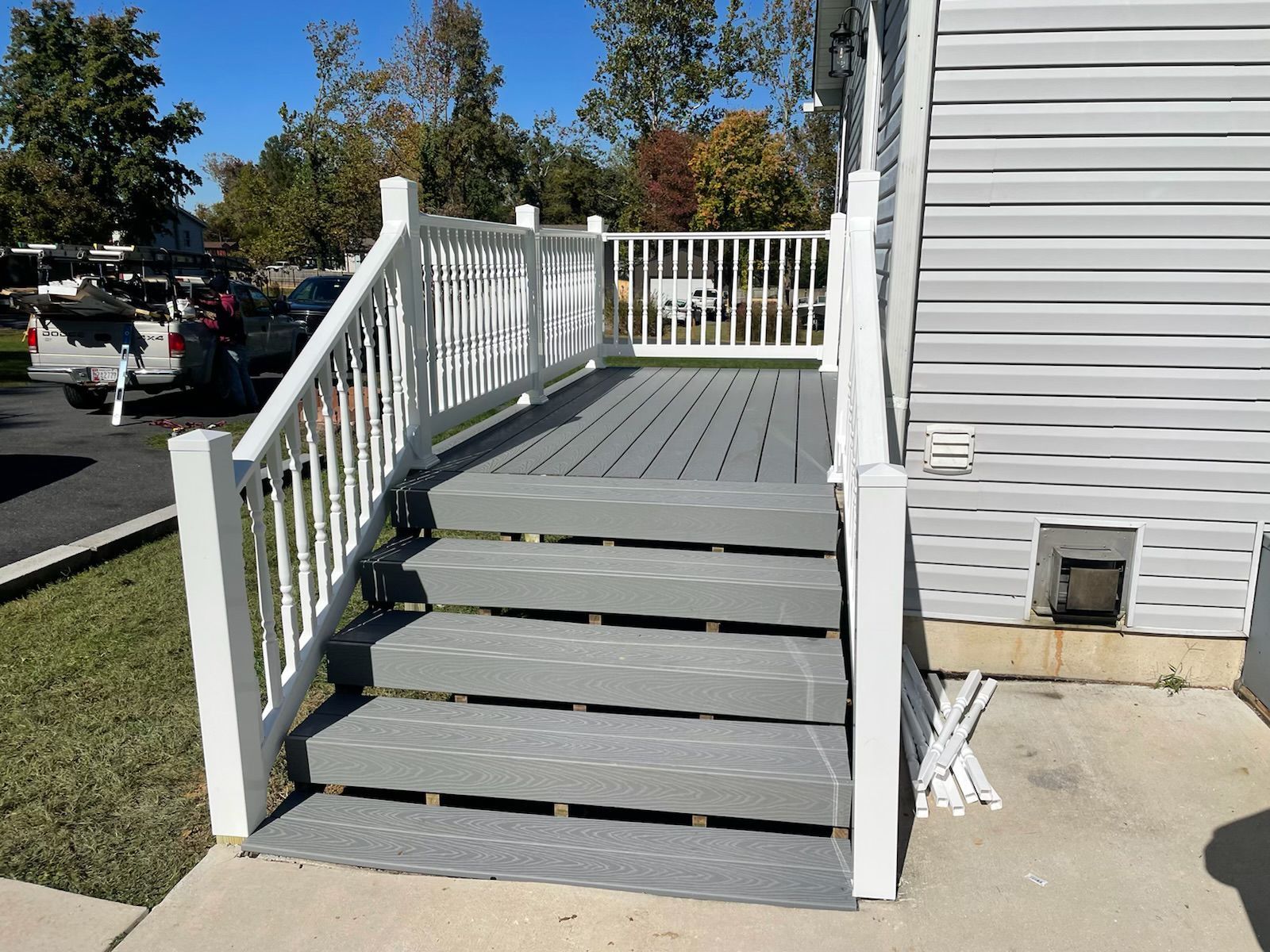 A white house with a gray deck and stairs