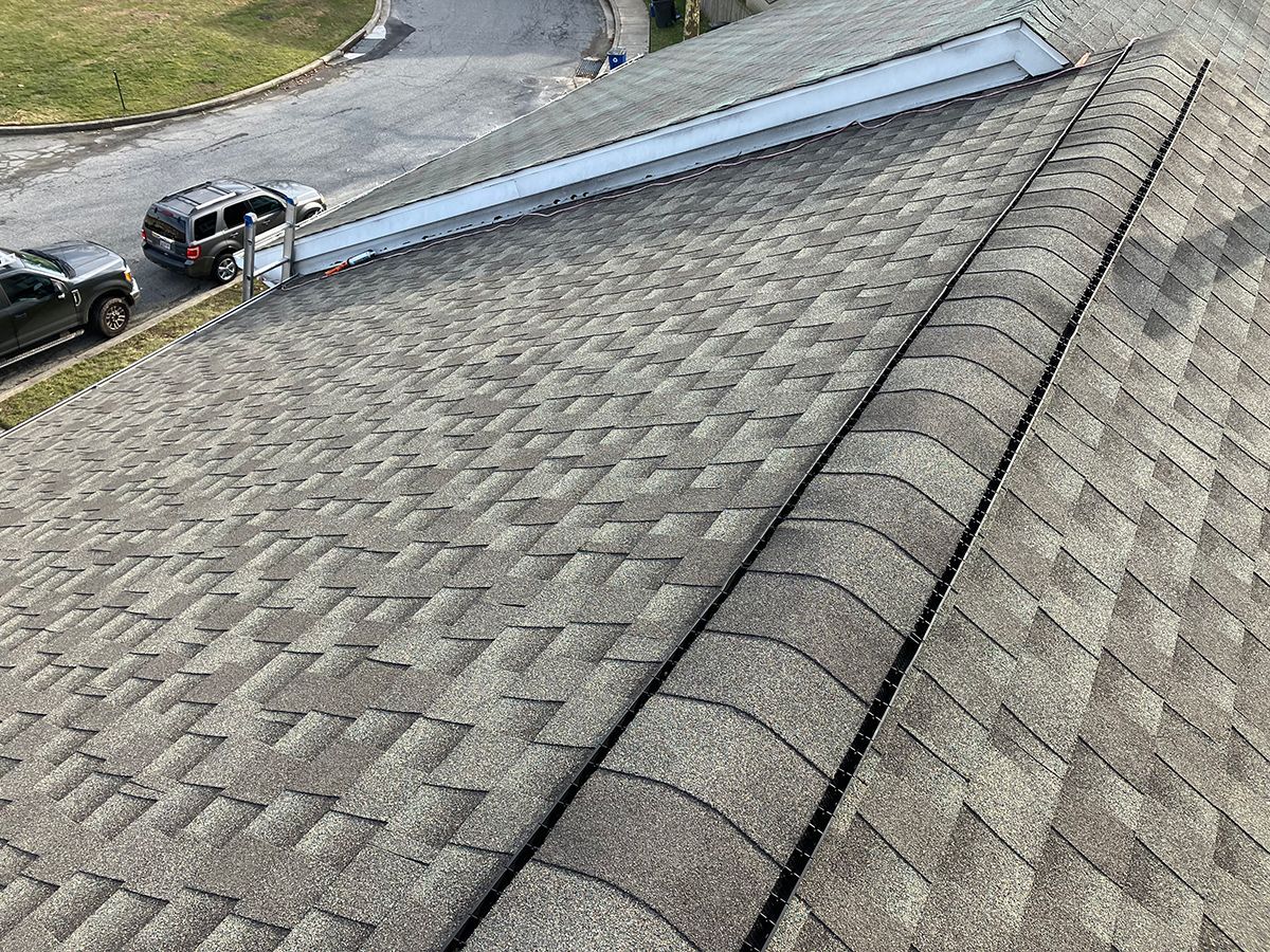 An aerial view of a roof with a car parked on the side of it.