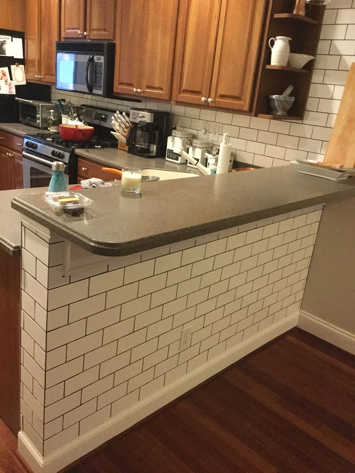 A kitchen with white brick walls and wooden cabinets