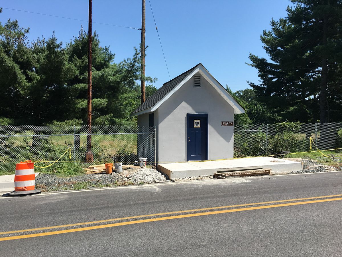 A small building is sitting on the side of the road
