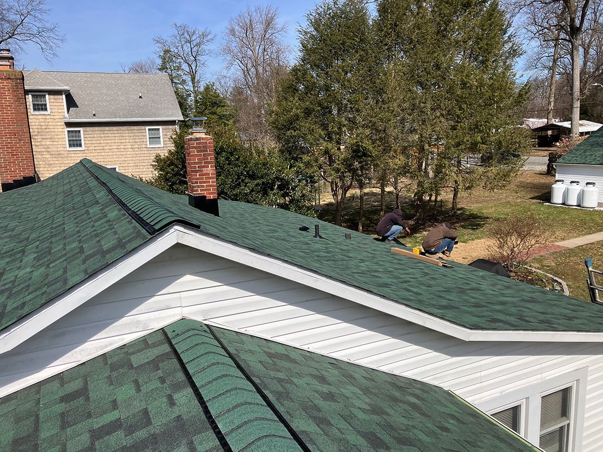 A man is working on the roof of a house.