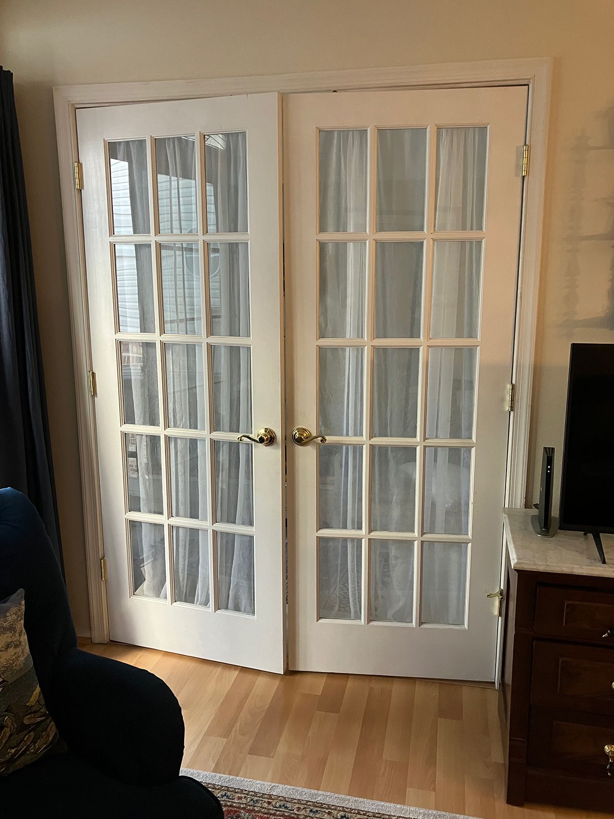 A living room with french doors and a chair