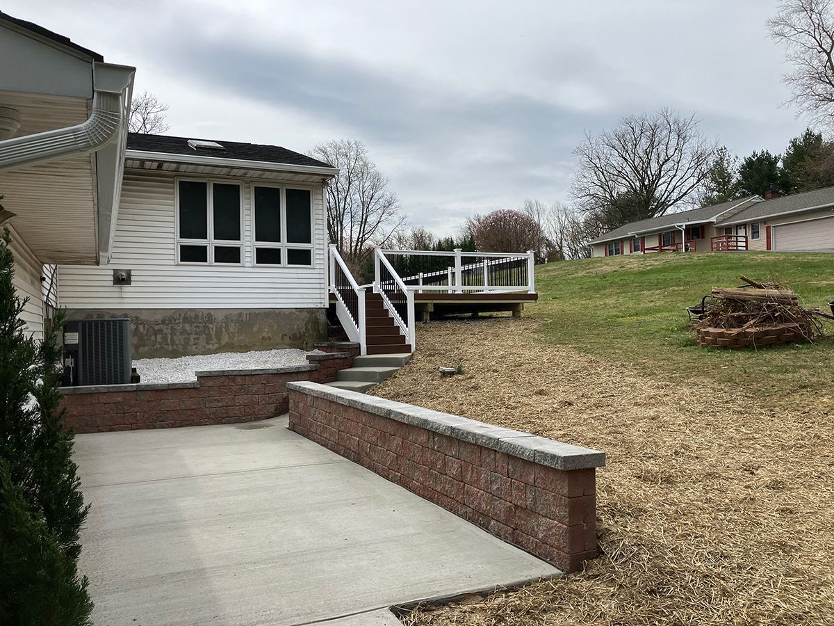 The backyard of a house with a brick wall and stairs leading up to it.