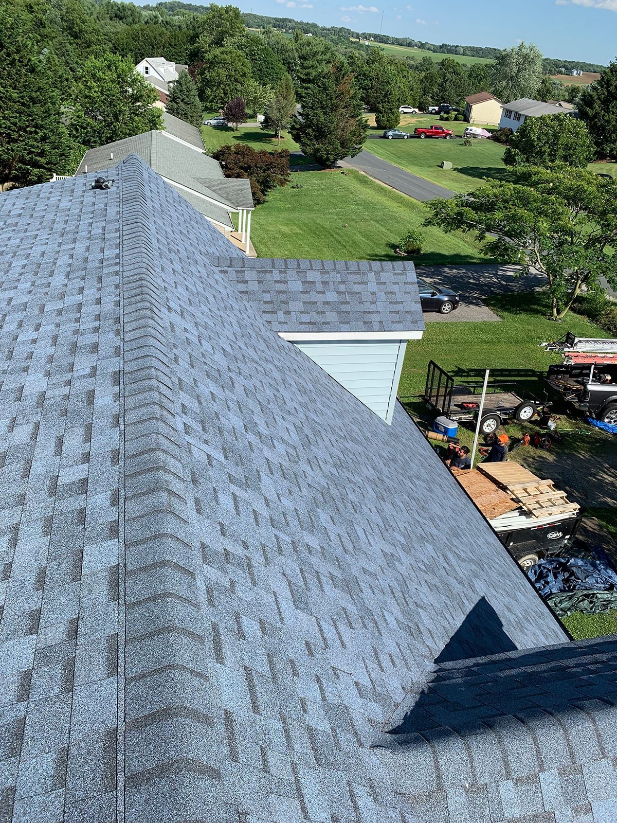 An aerial view of a roof with shingles on it in a residential area.