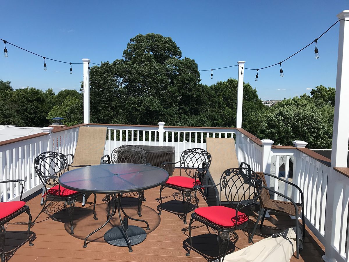 There is a table and chairs on the roof of a building.