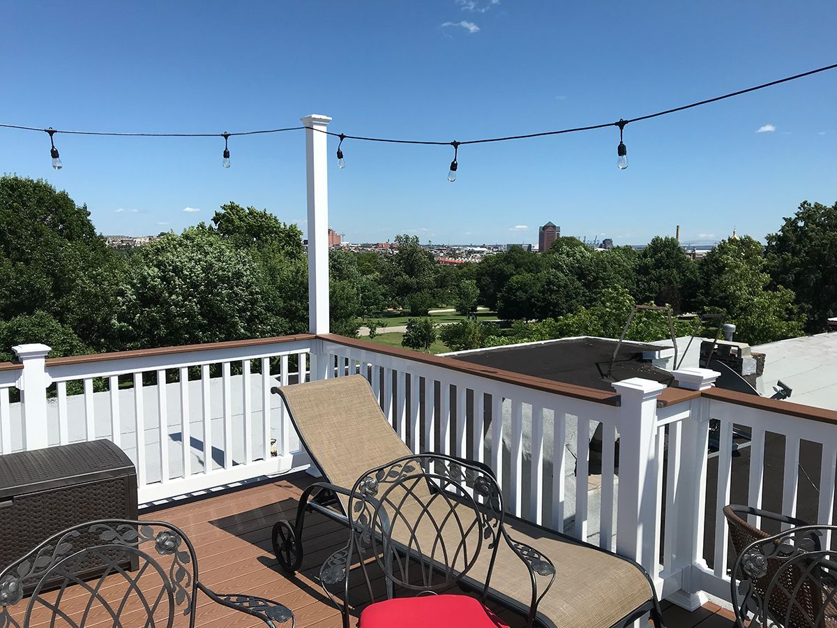 A rooftop deck with a view of a city and trees