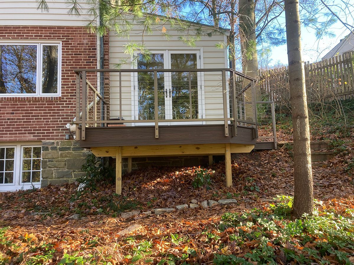 A brick house with a wooden deck in front of it.
