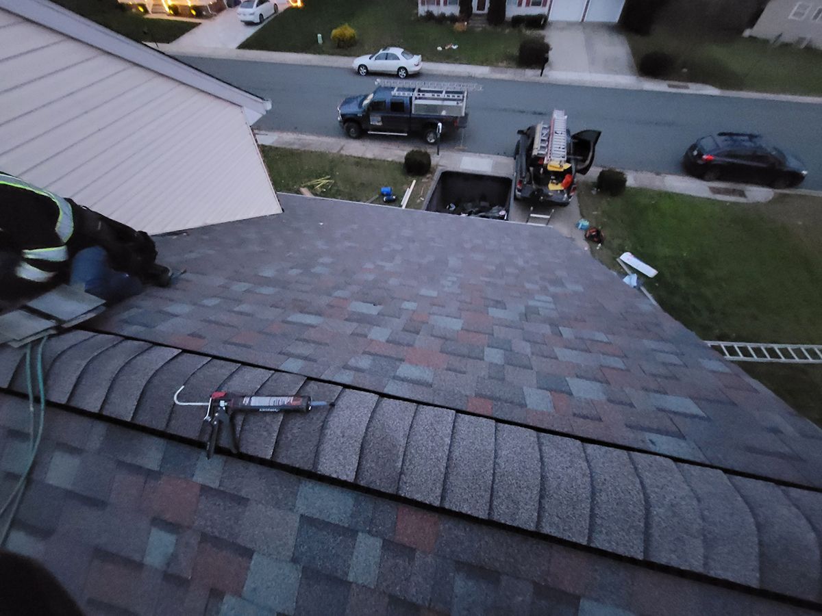 A man is working on the roof of a house.