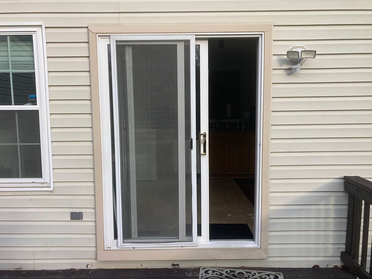 A white house with a sliding glass door and a window