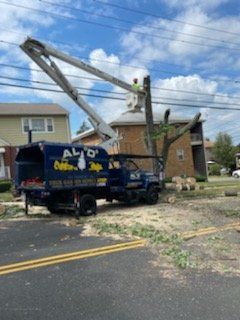 a truck with a crane on top of it is cutting a tree .