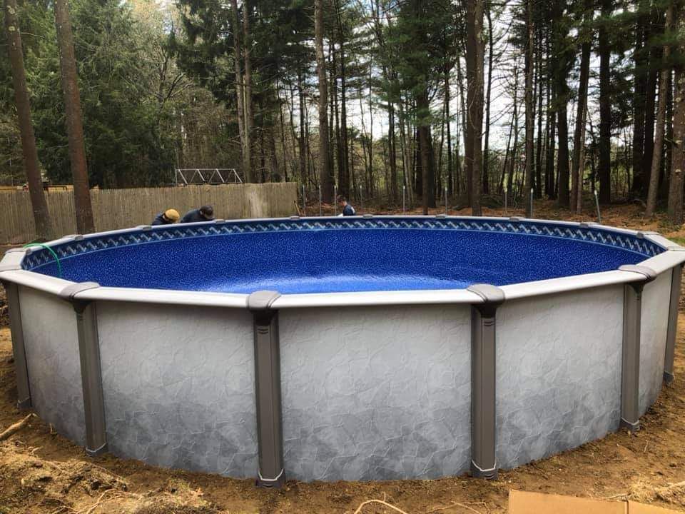 A large swimming pool is sitting in the middle of a forest.