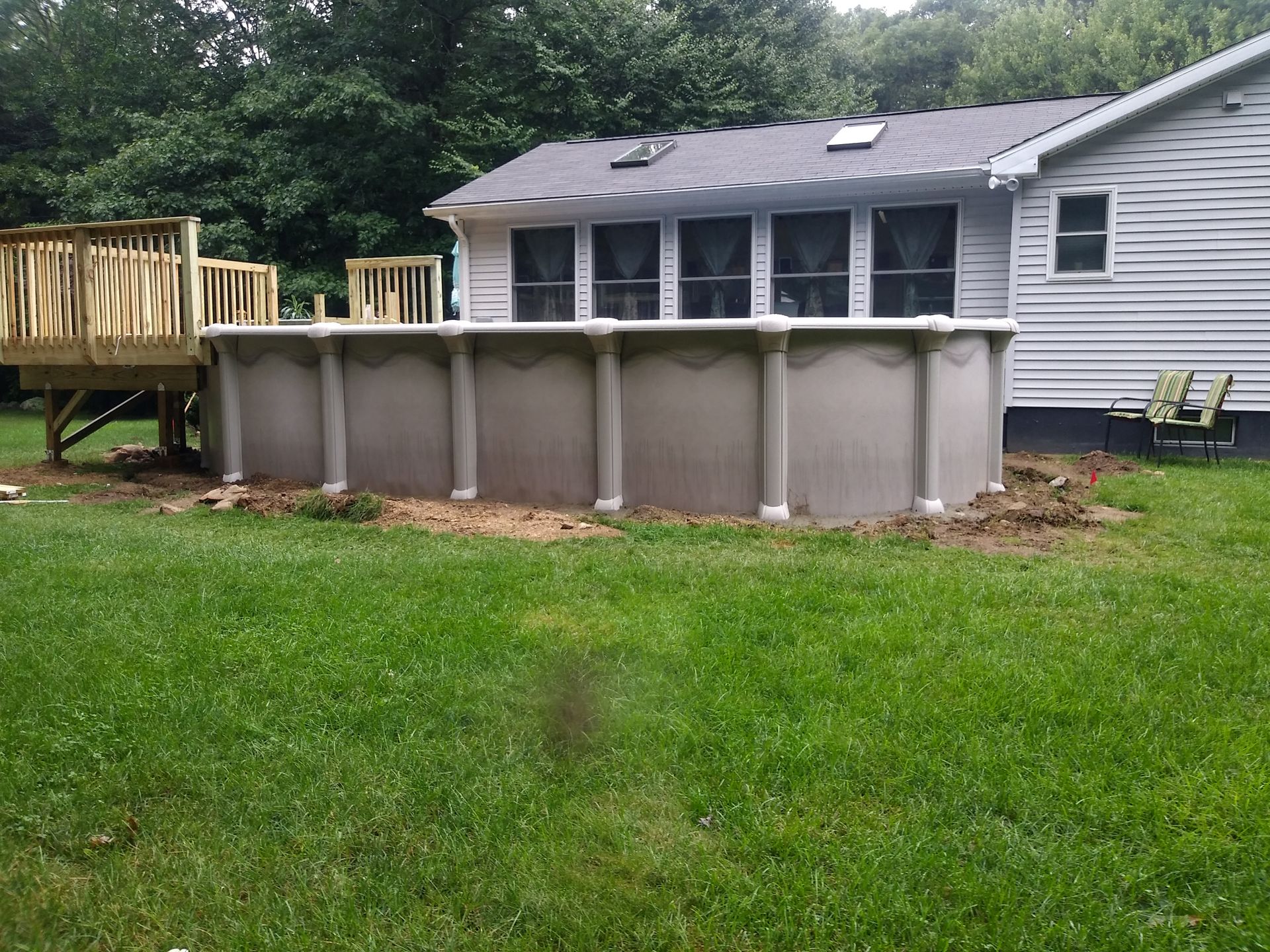 A large swimming pool is sitting in the backyard of a house.