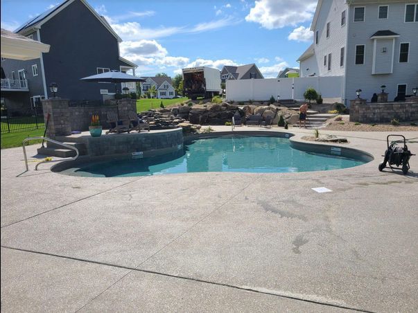 A large swimming pool in a backyard next to a house