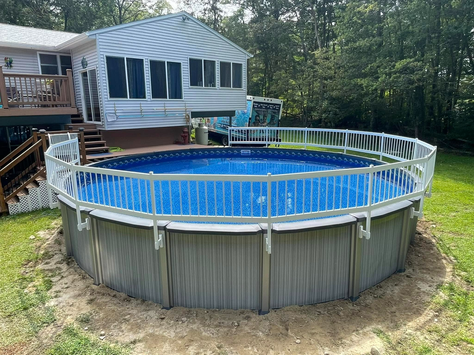 A large swimming pool is in the backyard of a house.