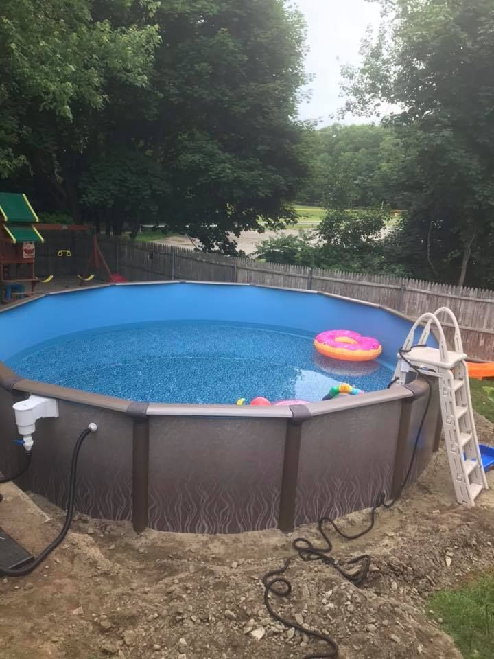 A large swimming pool with a ladder in the backyard.