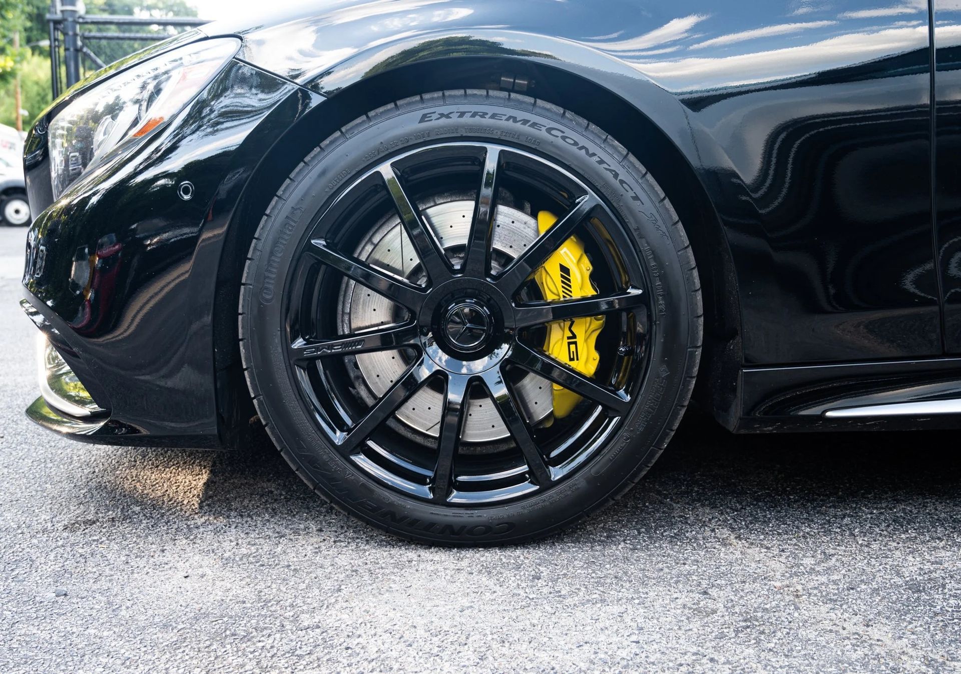 Black car wheel with yellow brake caliper.