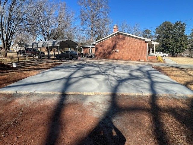 A concrete driveway is being built in front of a house